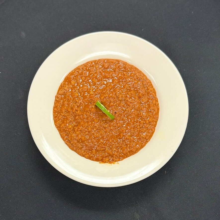 Ethiopian Misir Wot—spiced red lentils slow-simmered with onions, garlic, and traditional herbs, served on injera.